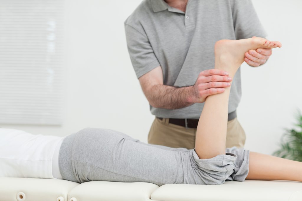 therapist massaging achilles tendon